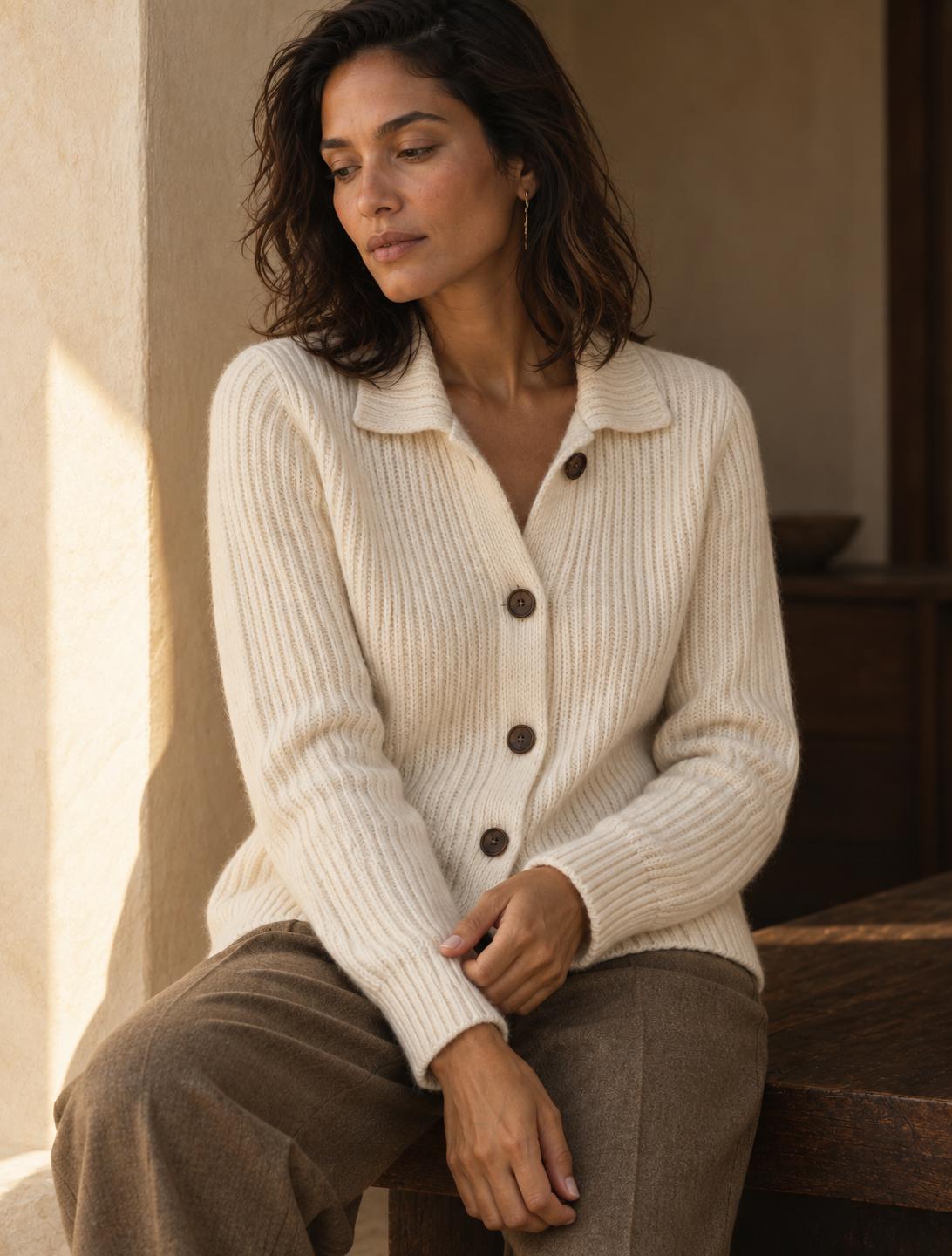 Maille ivoire, denim et cabas cognac dans un intérieur chaleureux.